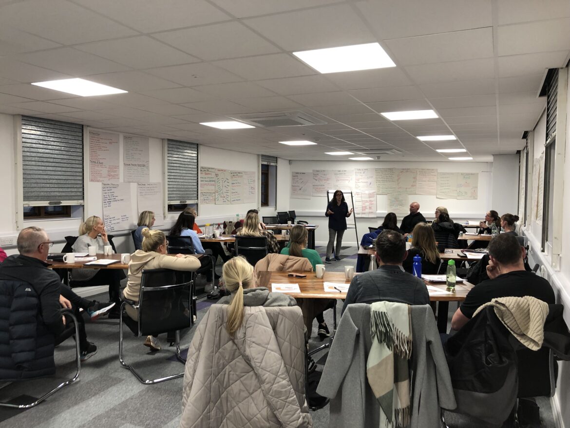Woman delivers training to room of people