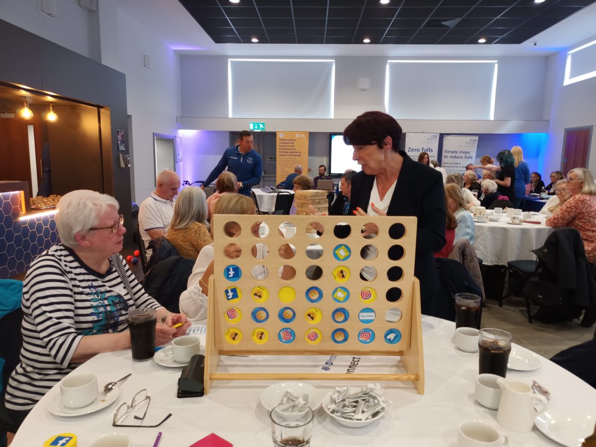 Cllr Christine Bannon speaks with residents at a table.