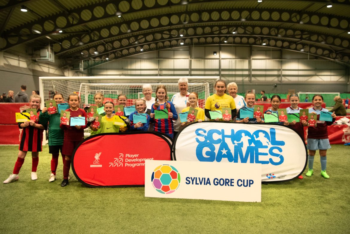 A group of school children stand with former England Women's footballers